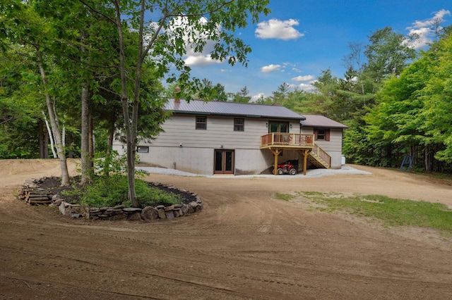 13 Seyah Rd, Shelburne, NH 03581 - view of front of house featuring driveway, a deck, stairs, french doors, and a metal roof
