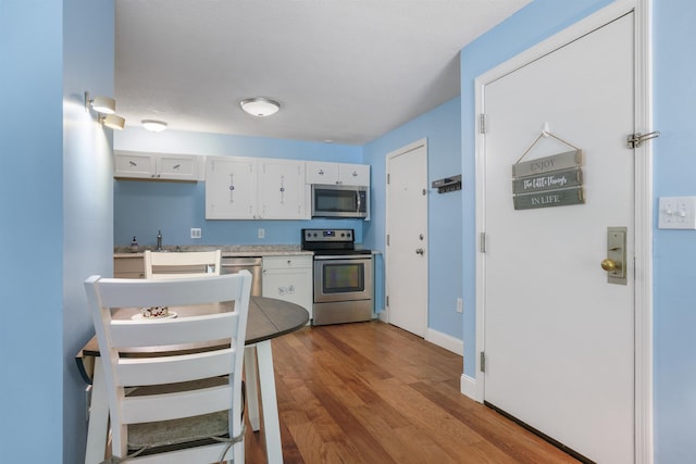 2 Autumn Leaf Dr Unit 20, Nashua, NH 03060 - kitchen with stainless steel appliances, wood finished floors, white cabinets, and light countertops