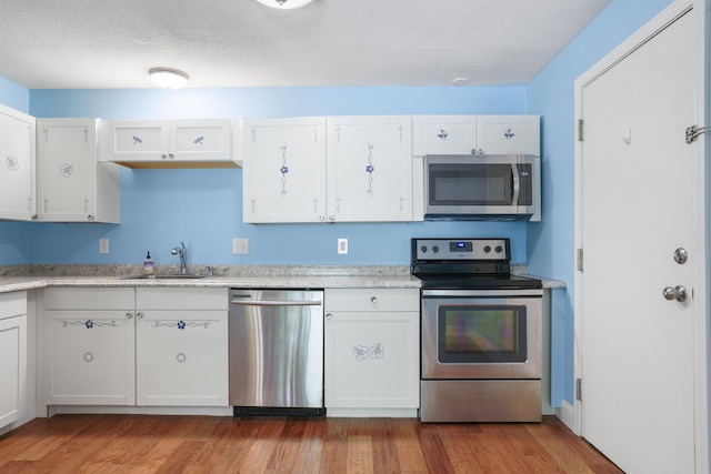 2 Autumn Leaf Dr Unit 20, Nashua, NH 03060 - kitchen with appliances with stainless steel finishes, light countertops, white cabinets, and wood finished floors