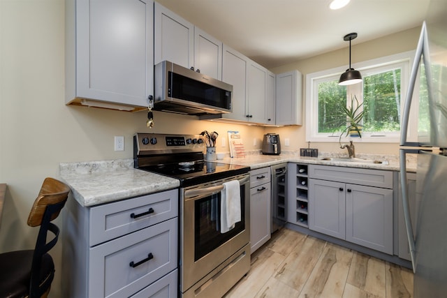 65 Glidden Rd, Croydon, NH 03773 - kitchen with stainless steel appliances, gray cabinetry, light wood-type flooring, and hanging light fixtures