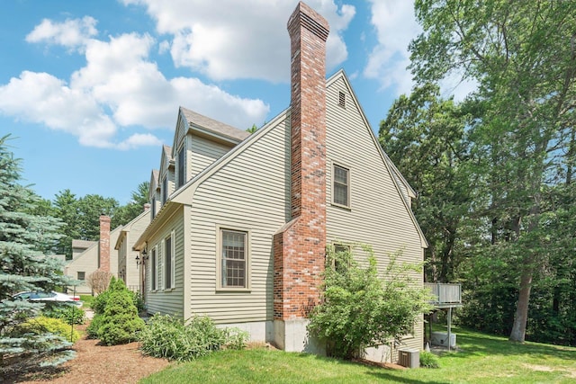 27 Olde Common Dr, Atkinson, NH 03811 - view of side of home featuring a chimney, a lawn, and a deck