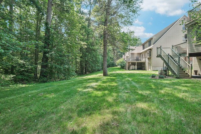 27 Olde Common Dr, Atkinson, NH 03811 - view of grassy yard featuring stairs and a deck