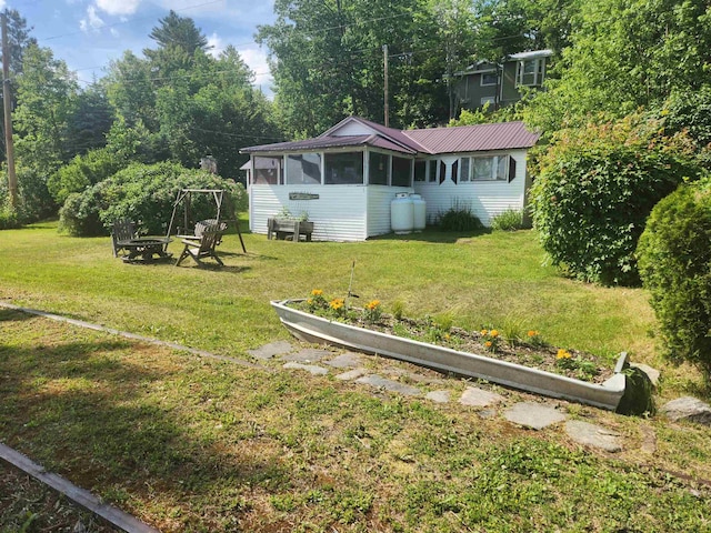 106 Nanas Ln, Concord, VT 05824 - view of green lawn featuring a sunroom and an outdoor fire pit