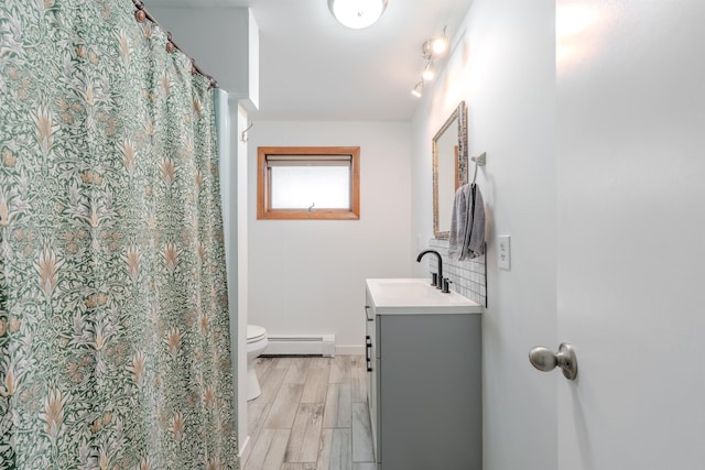 15 Prospect St, Farmington, NH 03835 - bathroom with baseboard heating, vanity, and wood finished floors