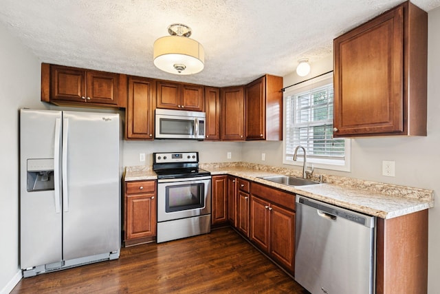 272 Winding Pond Rd Unit 272, Londonderry, NH 03053 - kitchen with stainless steel appliances, light countertops, dark wood finished floors, a textured ceiling, and brown cabinetry