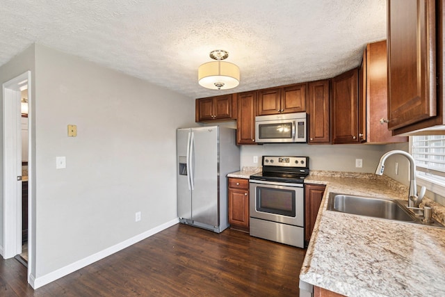 272 Winding Pond Rd Unit 272, Londonderry, NH 03053 - kitchen with stainless steel appliances, light countertops, dark wood finished floors, a textured ceiling, and brown cabinetry