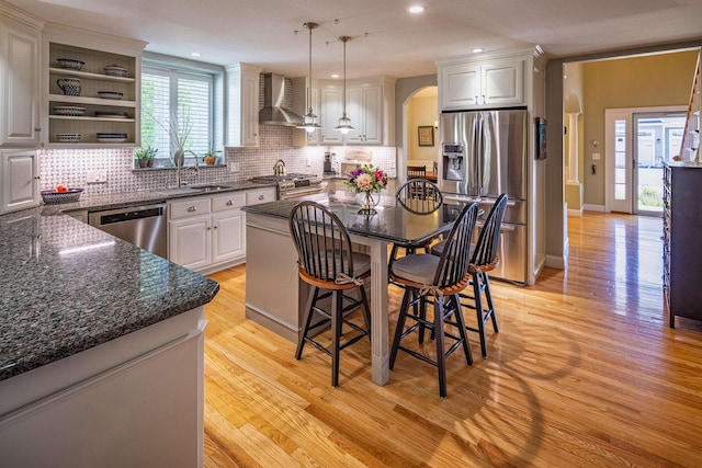 1 Sonia Dr, Dover, NH 03820 - kitchen featuring appliances with stainless steel finishes, wall chimney exhaust hood, tasteful backsplash, arched walkways, and recessed lighting