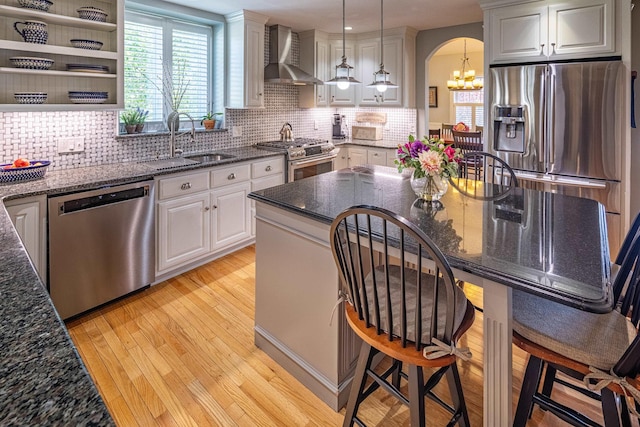 1 Sonia Dr, Dover, NH 03820 - kitchen with wall chimney exhaust hood, appliances with stainless steel finishes, a chandelier, light wood finished floors, and white cabinetry