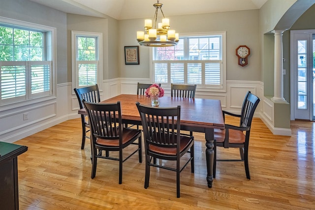 1 Sonia Dr, Dover, NH 03820 - dining area with ornate columns, light wood-style floors, a chandelier, a decorative wall, and wainscoting