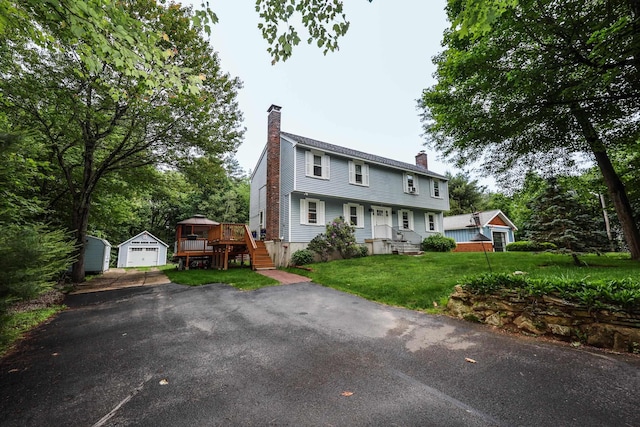 2L Homestead Dr Unit L, Derry, NH 03038 - colonial house featuring a chimney, an outdoor structure, a detached garage, driveway, and a front yard