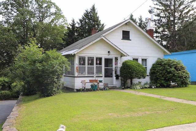 79 Wall St, Springfield, VT 05156 - bungalow-style home featuring a chimney, a front lawn, and a sunroom