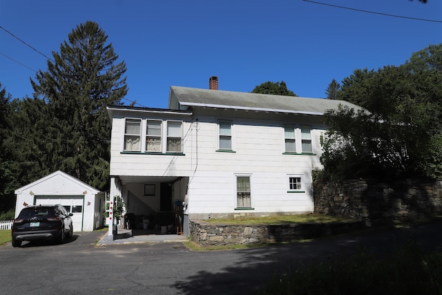 79 Wall St, Springfield, VT 05156 - view of home's exterior featuring an outbuilding, a chimney, and a detached garage