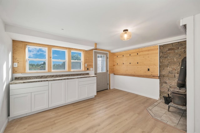 145 Bow Lake Rd, Barnstead, NH 03218 - kitchen featuring light wood-type flooring, a wood stove, and wooden walls