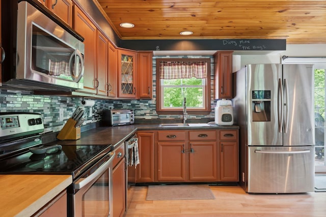 115 Blackwater Rd, Somersworth, NH 03878 - kitchen with appliances with stainless steel finishes, brown cabinets, wood ceiling, tasteful backsplash, and light wood-style floors