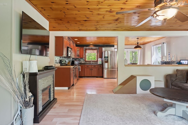 115 Blackwater Rd, Somersworth, NH 03878 - kitchen with stainless steel appliances, wood ceiling, light wood-style floors, brown cabinetry, and decorative backsplash