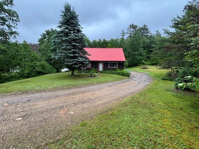 131 Gilmanton Rd, Belmont, NH 03220 - view of front of property featuring a front lawn, driveway, a metal roof, and a wooded view