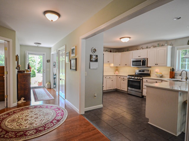 138 Page Rd, New London, NH 03257 - kitchen with appliances with stainless steel finishes, white cabinets, light countertops, and a peninsula