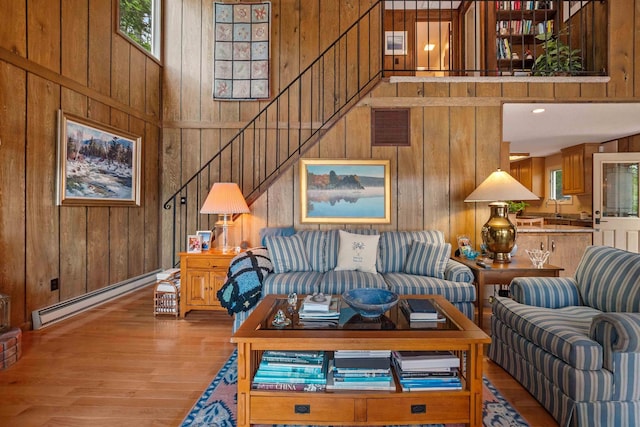 98 Marys Rd, Sunapee, NH 03782 - living area featuring a baseboard radiator, wooden walls, wood finished floors, and a high ceiling