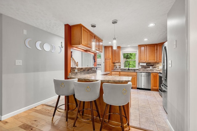 56 Durham Rd Unit 62, Dover, NH 03820 - kitchen with dishwasher, backsplash, recessed lighting, a peninsula, and a breakfast bar area