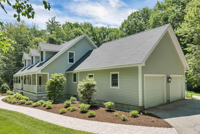 292 Forest Rd, Wolfeboro, NH 03894 - view of front of home with covered porch, asphalt driveway, roof with shingles, and view of scattered trees