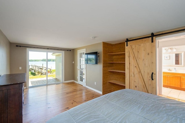27 Wentworth Ter, Dover, NH 03820 - bedroom with a barn door, access to outside, light wood-type flooring, and ensuite bath