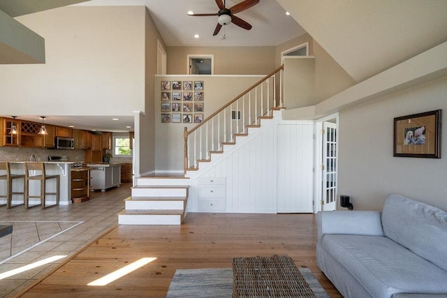 27 Wentworth Ter, Dover, NH 03820 - living area with high vaulted ceiling, a ceiling fan, light wood-style floors, stairs, and recessed lighting