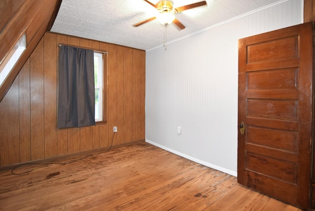 49 Bowker St, Claremont, NH 03743 - empty room featuring a ceiling fan, hardwood / wood-style floors, and wooden walls