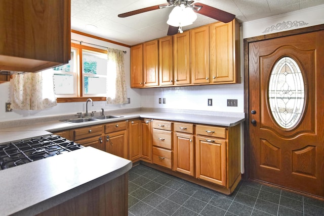 49 Bowker St, Claremont, NH 03743 - kitchen featuring a ceiling fan, crown molding, brown cabinetry, and light countertops