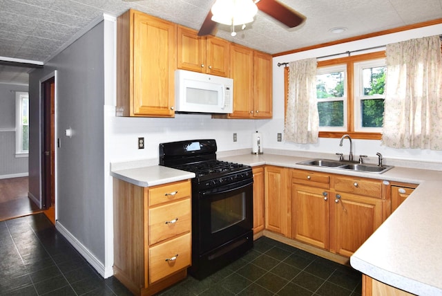 49 Bowker St, Claremont, NH 03743 - kitchen with white microwave, black gas range oven, dark tile patterned floors, plenty of natural light, and crown molding