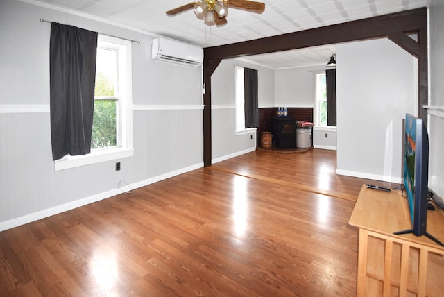 49 Bowker St, Claremont, NH 03743 - unfurnished living room with a wall unit AC, plenty of natural light, ceiling fan, and wood finished floors