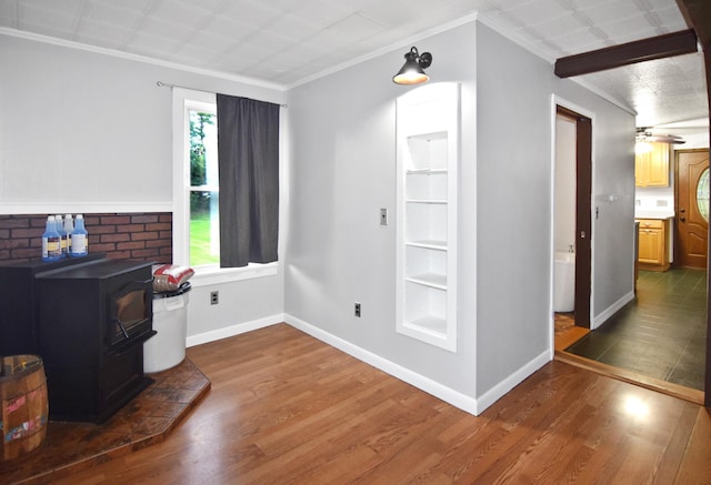 49 Bowker St, Claremont, NH 03743 - living area featuring a wood stove, wood finished floors, built in features, ornamental molding, and a ceiling fan