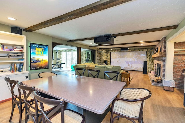 16 Storybrook Ln, Amherst, NH 03031 - dining room with beamed ceiling, light wood-style flooring, and a fireplace
