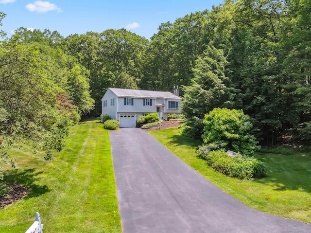 5 Cowin Rd, Merrimack, NH 03054 - split foyer home with an attached garage, asphalt driveway, a front lawn, and a forest view