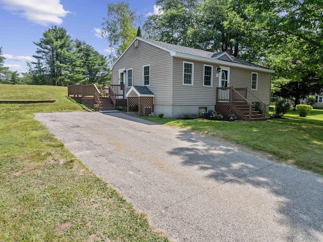 14 Anagance Ln, Wolfeboro, NH 03894 - manufactured / mobile home featuring a front lawn, a wooden deck, roof with shingles, and driveway