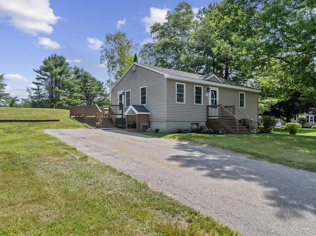 14 Anagance Ln, Wolfeboro, NH 03894 - manufactured / mobile home featuring a front yard, a wooden deck, and asphalt driveway