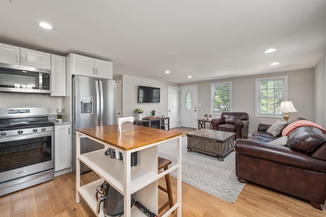 14 Anagance Ln, Wolfeboro, NH 03894 - kitchen featuring stainless steel appliances, white cabinets, light wood-style flooring, open floor plan, and recessed lighting