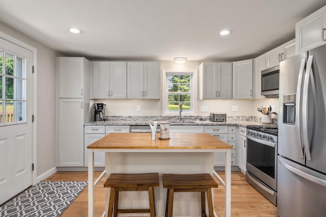 14 Anagance Ln, Wolfeboro, NH 03894 - kitchen with stainless steel appliances, a kitchen breakfast bar, light wood-type flooring, plenty of natural light, and recessed lighting