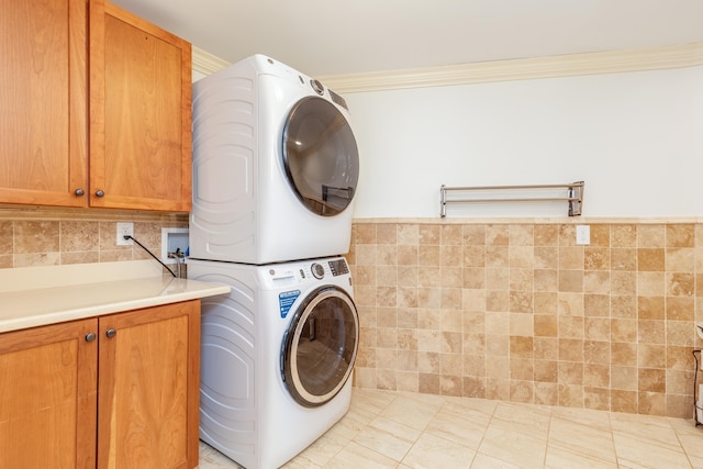 123 Stephen Dr, Goffstown, NH 03045 - washroom featuring stacked washer / drying machine, cabinet space, and crown molding