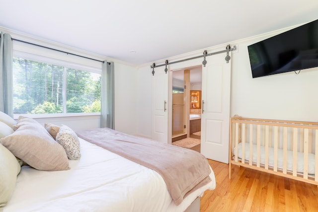 123 Stephen Dr, Goffstown, NH 03045 - bedroom with light wood-style flooring and a barn door