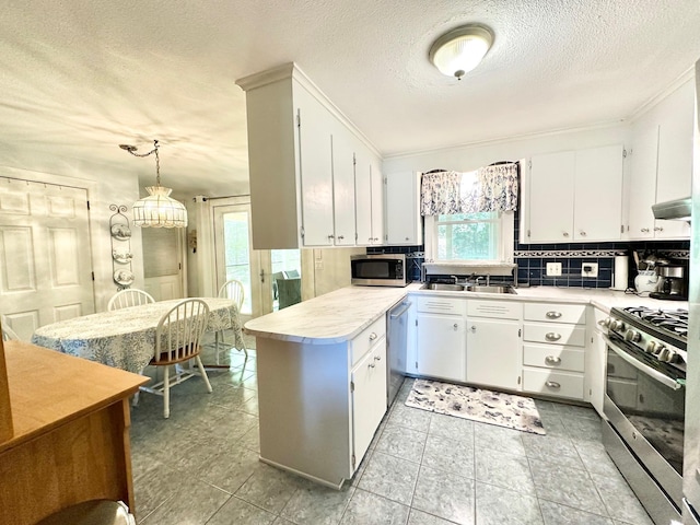 22 Mason Rd, Merrimack, NH 03054 - kitchen with appliances with stainless steel finishes, light countertops, tasteful backsplash, a textured ceiling, and a peninsula