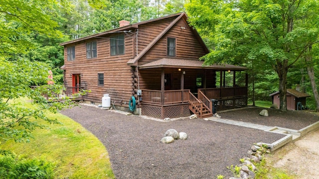 104 Rolling Ridge Rd, Bartlett, NH 03812 - view of front of property featuring a chimney, log siding, a porch, and a storage shed