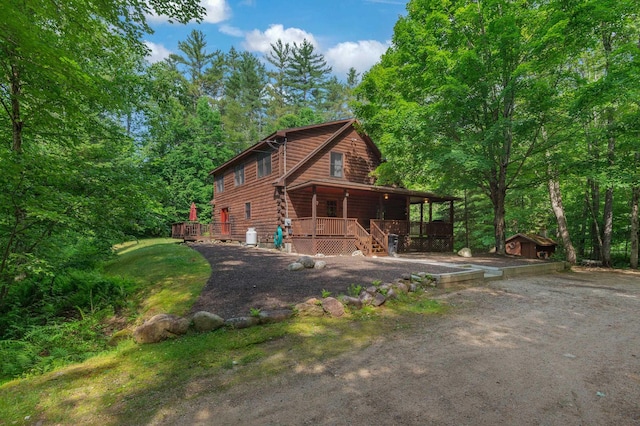 104 Rolling Ridge Rd, Bartlett, NH 03812 - view of front facade with a porch, a shed, and log siding