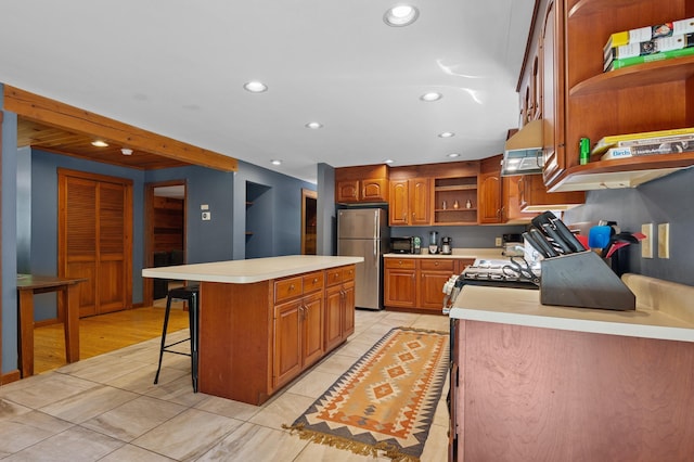 104 Rolling Ridge Rd, Bartlett, NH 03812 - kitchen featuring open shelves, appliances with stainless steel finishes, a center island, light countertops, and a kitchen bar