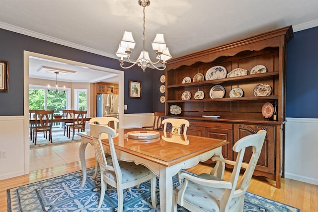 9 Deerhaven Dr, Exeter, NH 03833 - dining space with a chandelier, a wainscoted wall, ornamental molding, and light wood-style floors