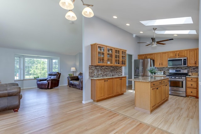 4 Lancer Ln, Danville, NH 03819 - kitchen featuring appliances with stainless steel finishes, open floor plan, a skylight, backsplash, and light wood finished floors