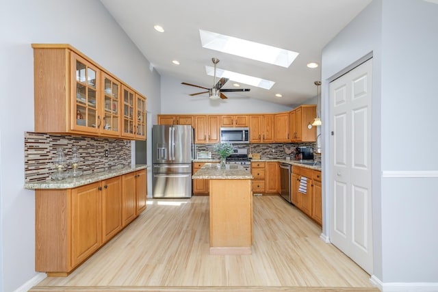 4 Lancer Ln, Danville, NH 03819 - kitchen featuring appliances with stainless steel finishes, a skylight, decorative backsplash, light stone counters, and vaulted ceiling