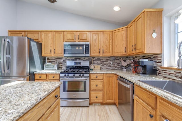 4 Lancer Ln, Danville, NH 03819 - kitchen with appliances with stainless steel finishes, vaulted ceiling, light wood-style floors, backsplash, and light stone countertops