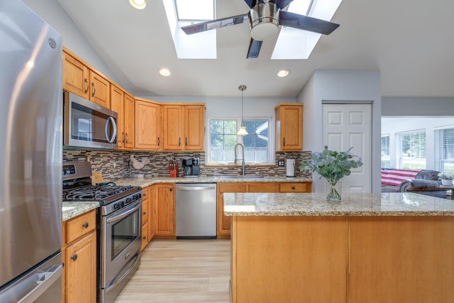 4 Lancer Ln, Danville, NH 03819 - kitchen featuring appliances with stainless steel finishes, a skylight, backsplash, light wood-style flooring, and ceiling fan