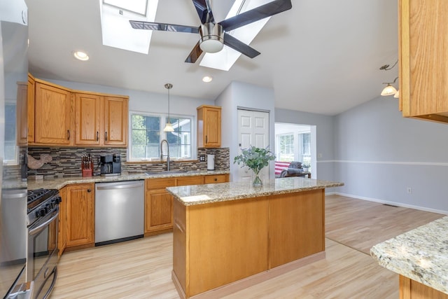 4 Lancer Ln, Danville, NH 03819 - kitchen featuring stainless steel appliances, a skylight, backsplash, light wood-type flooring, and a kitchen island