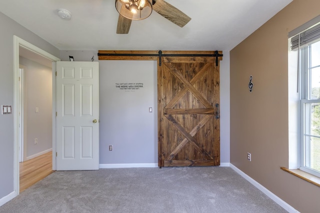 4 Lancer Ln, Danville, NH 03819 - unfurnished bedroom featuring carpet flooring, a barn door, and a ceiling fan